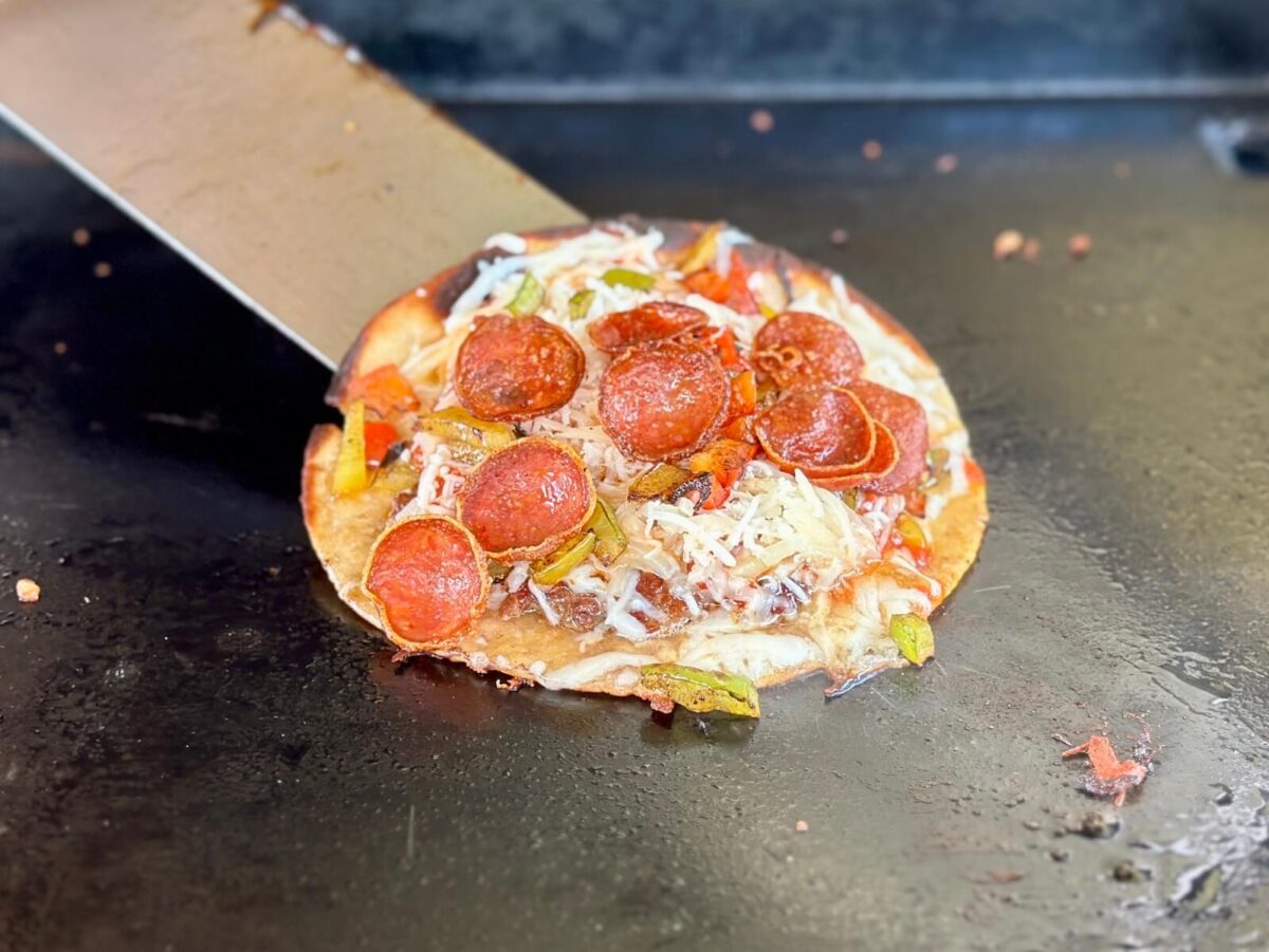 cooking a smash taco pizza on a Blackstone griddle
