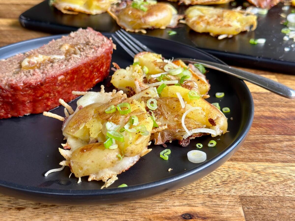 smashed potatoes on a plate with a slice of meatloaf