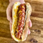 hot dog with a sweet onion mustard sauce on a bun