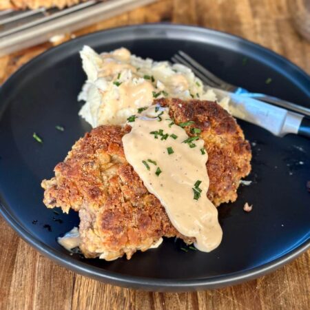 country fried steak with gravy and mashed potatoes on a plate