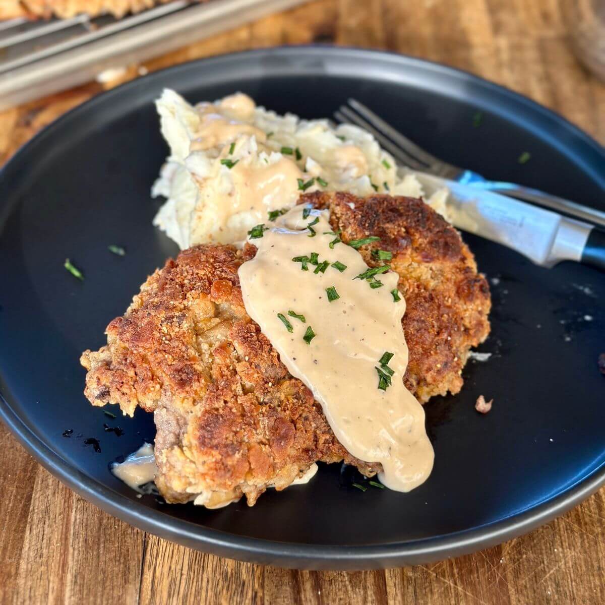 country fried steak with gravy and mashed potatoes on a plate
