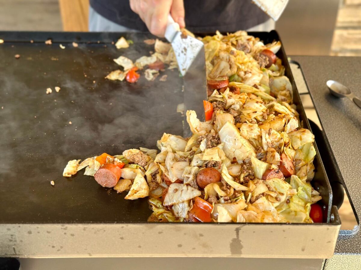 pushing dirty cabbage to the side of a griddle