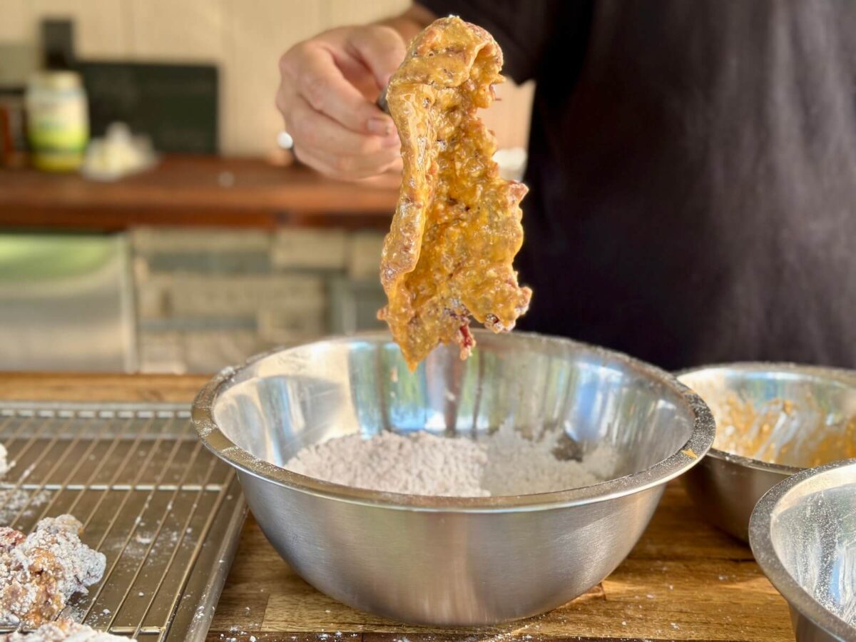 a piece of cube steak coated in an egg mixture for breading