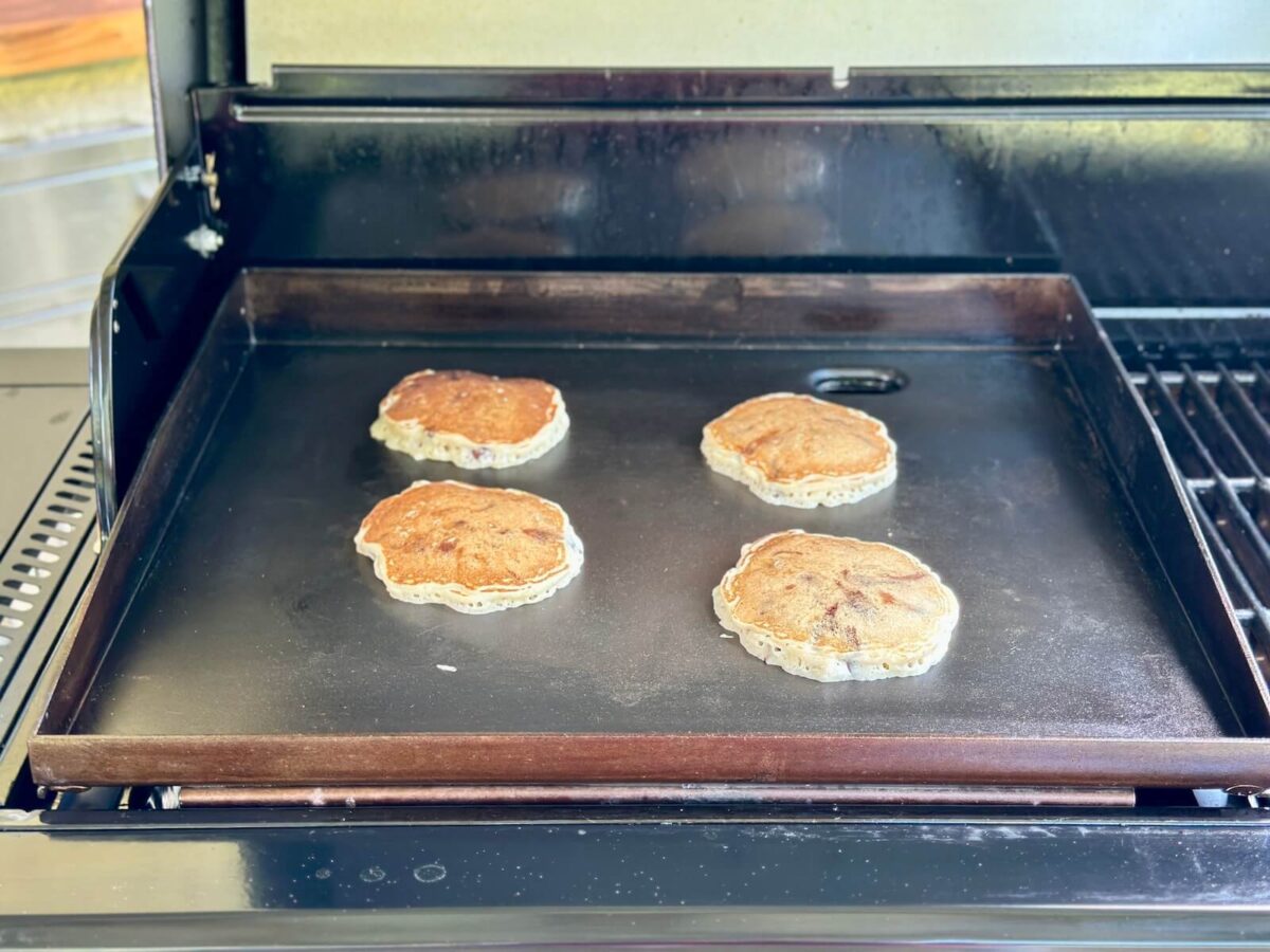 cooking banana chocolate chip pancakes on a griddle