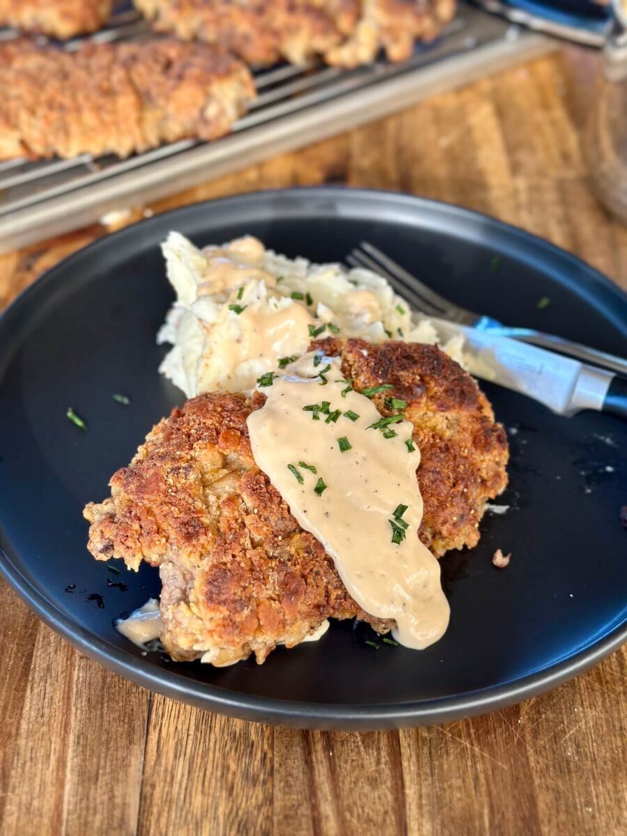 country fried steak with gravy and mashed potatoes on a plate