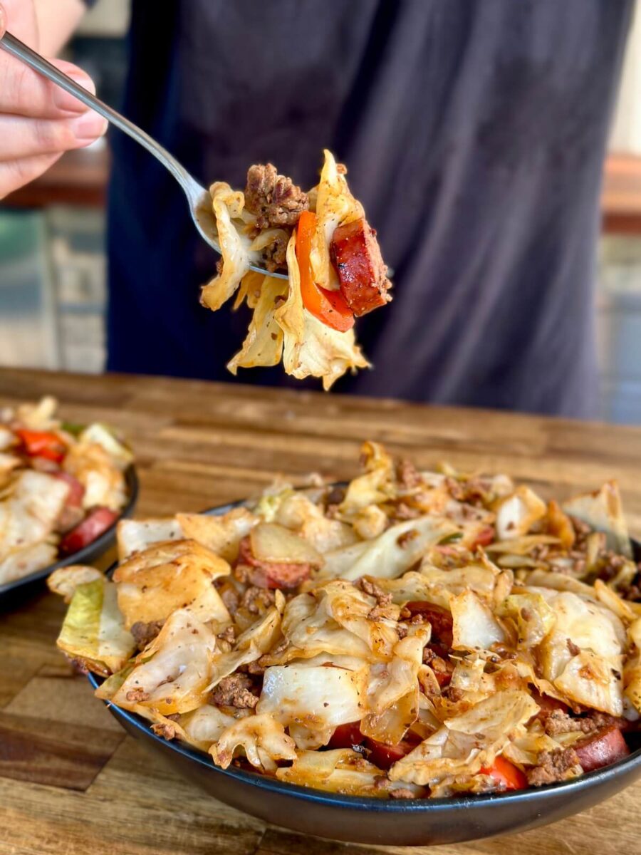 dirty cabbage with smoked sausage and ground beef on a fork