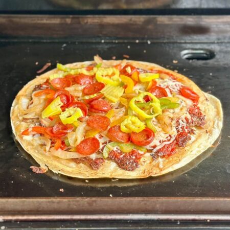 cooking a tortilla pizza on a Blackstone griddle