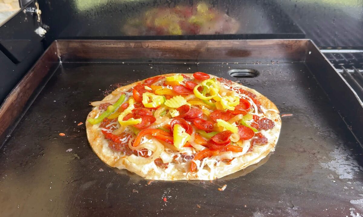 cooking a tortilla pizza on a griddle