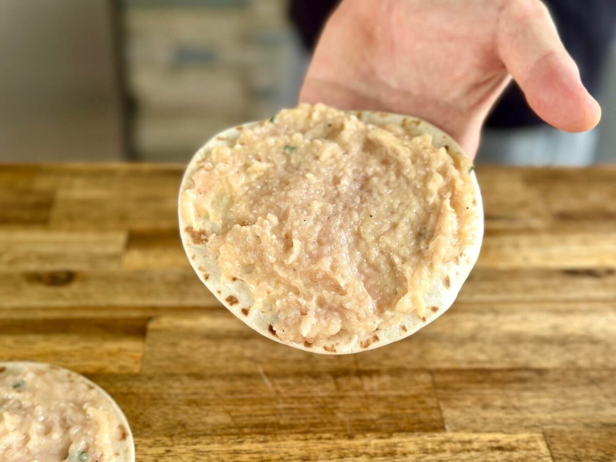 ground chicken mixture pressed flat on a flour tortilla