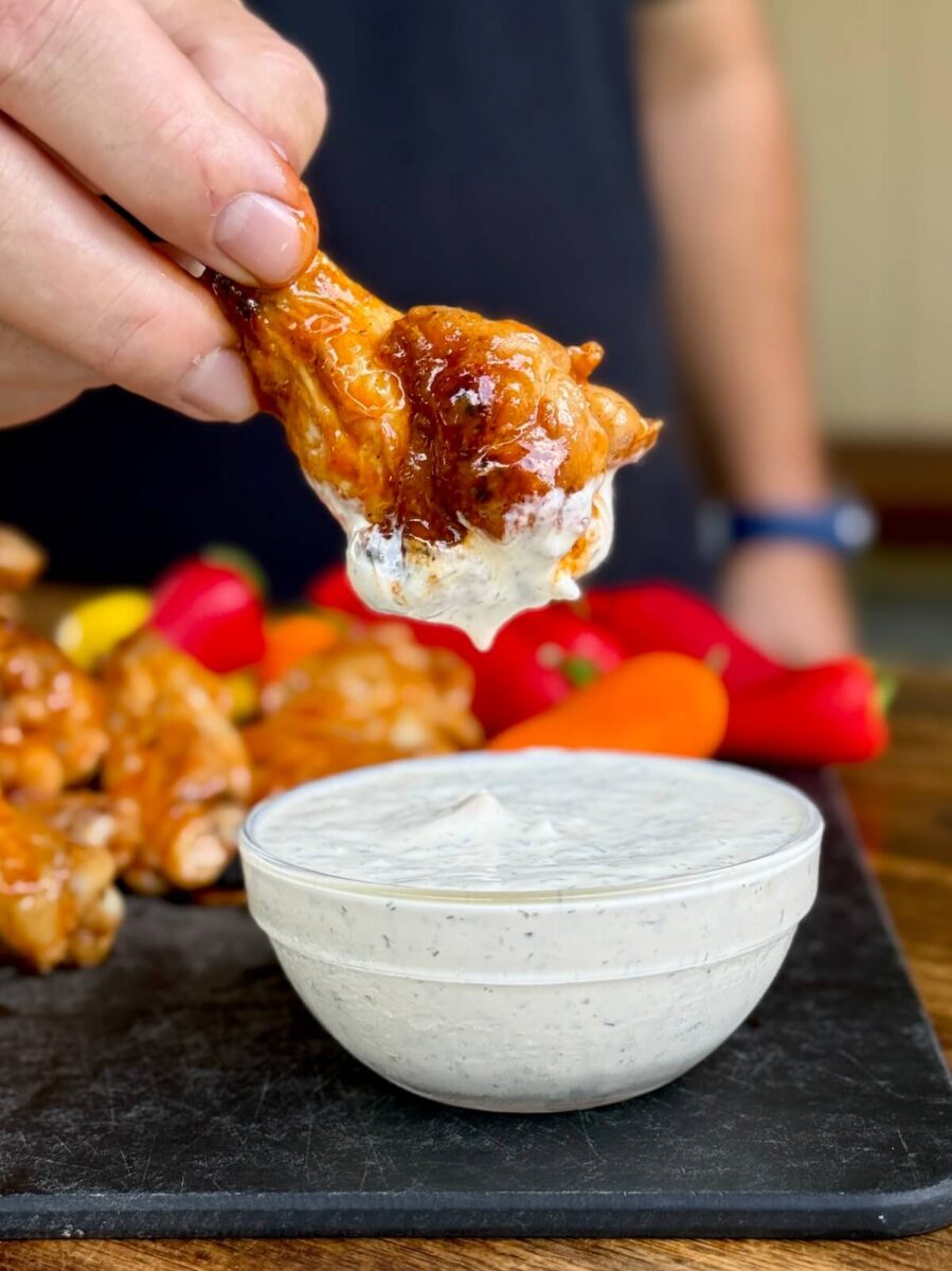 dipping a buffalo chicken wing into homemade ranch dressing