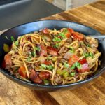 dirty spaghetti with ground beef, andouille sausage, and vegetables