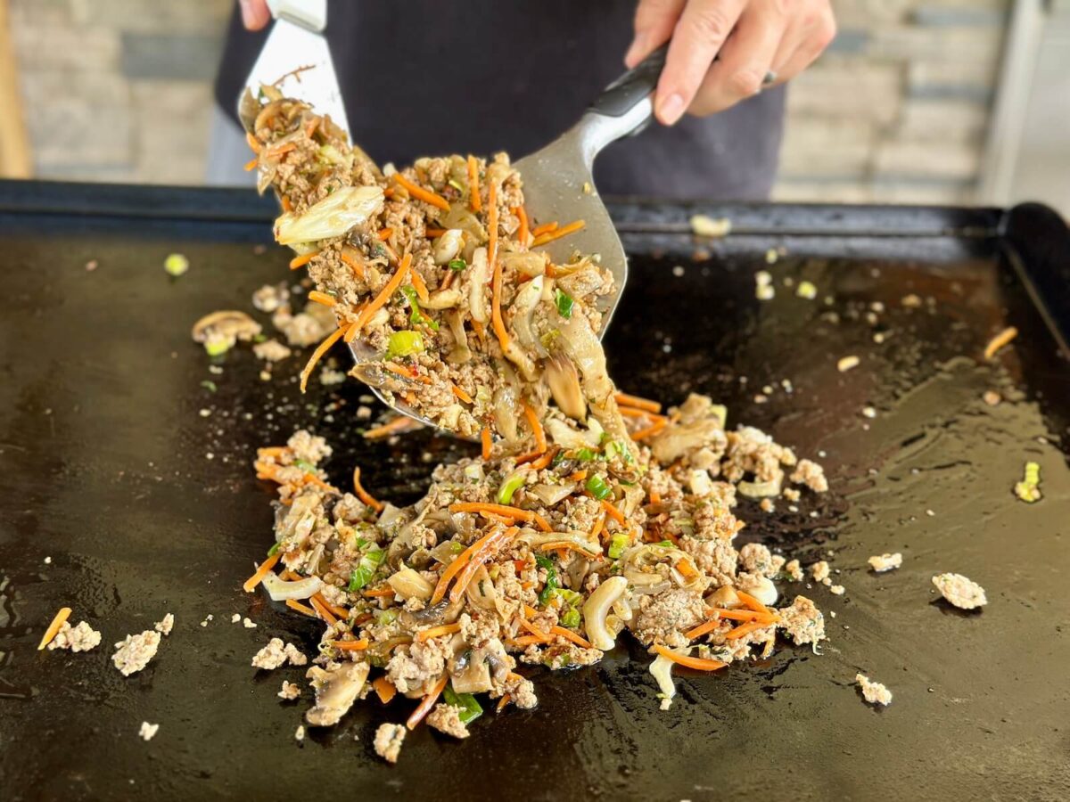 mixing dumpling in a bowl on a griddle