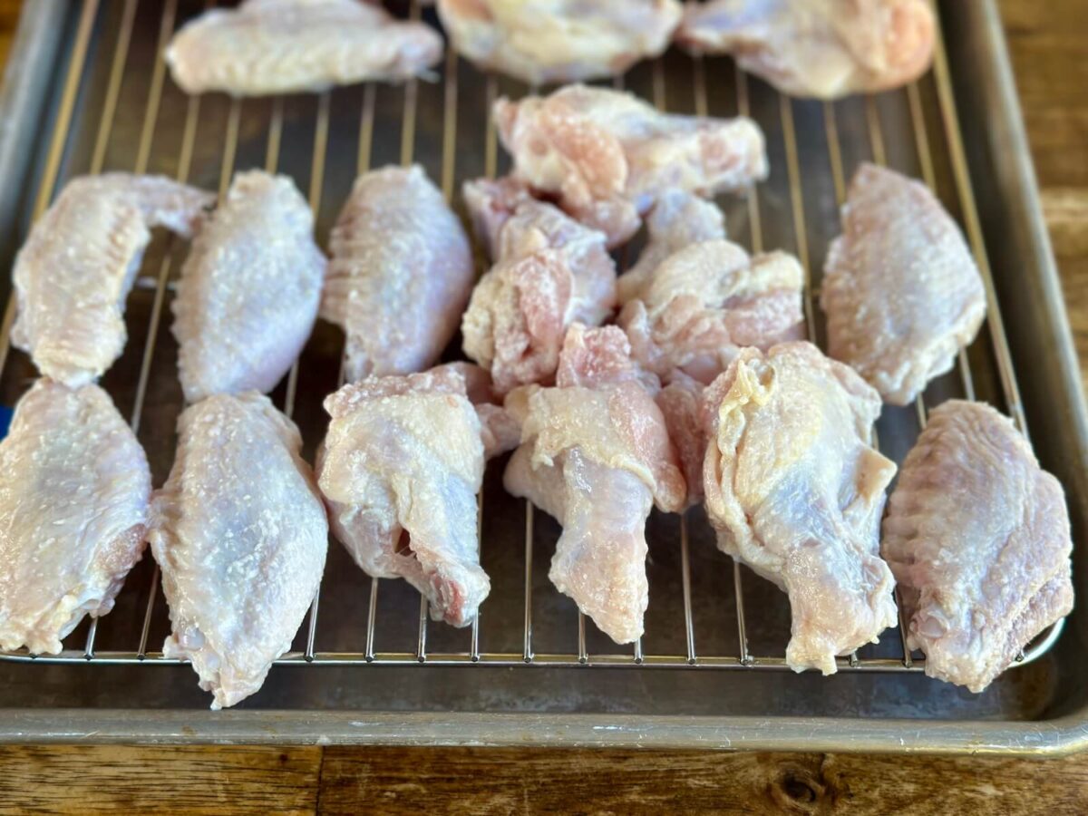 dry brining chicken wings on a wire rack set on top of a sheet tray