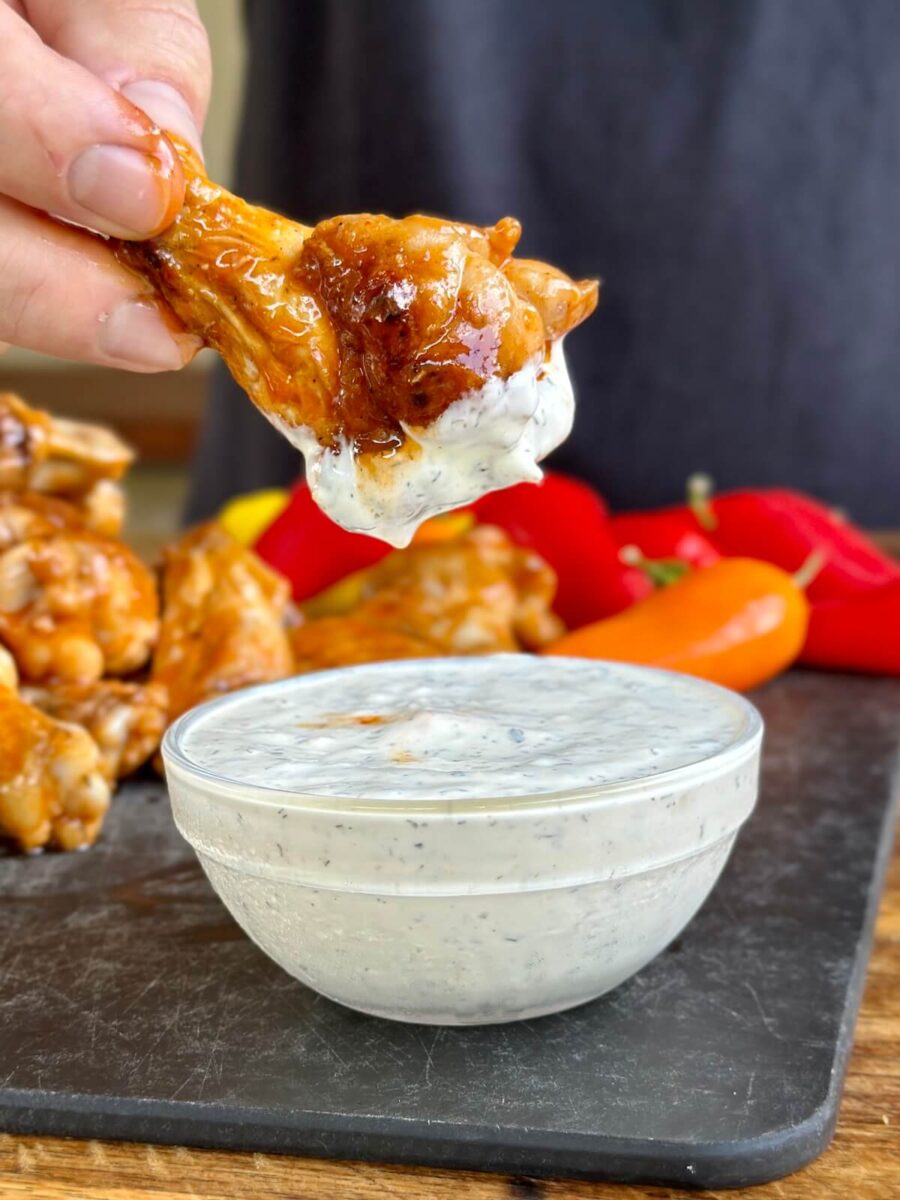 dipping a crispy buffalo chicken wing in Ranch dressing